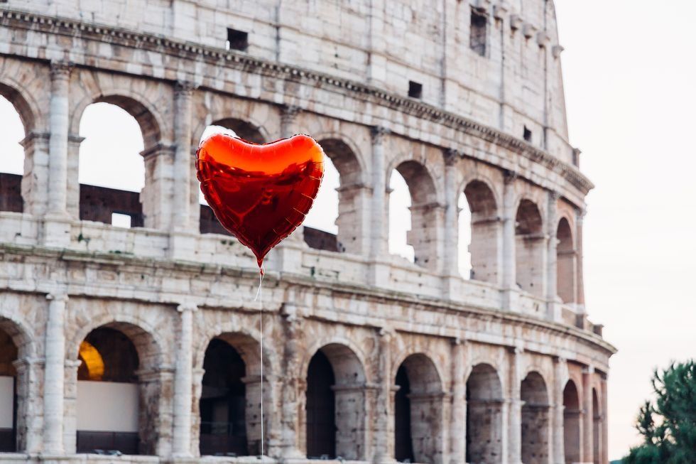 heart shaped balloon floating near coliseum, rome, italy