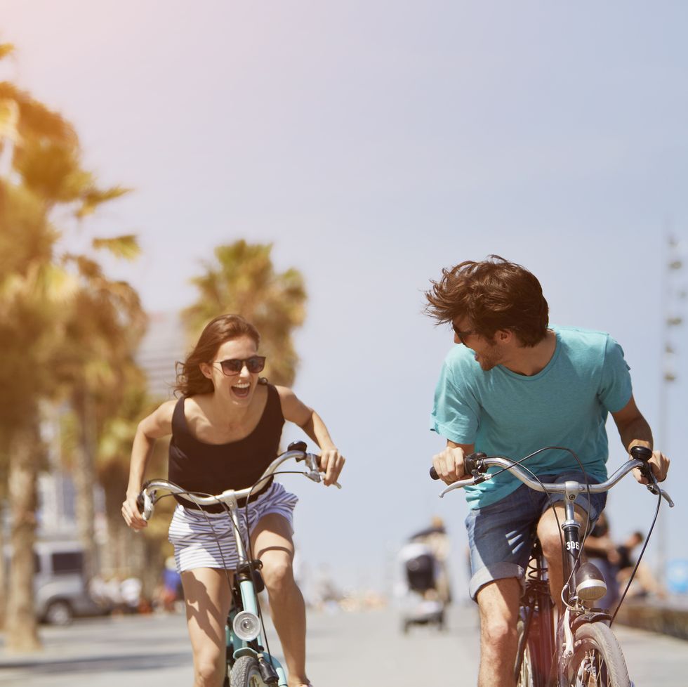 woman and man riding bicycles in some tropical location