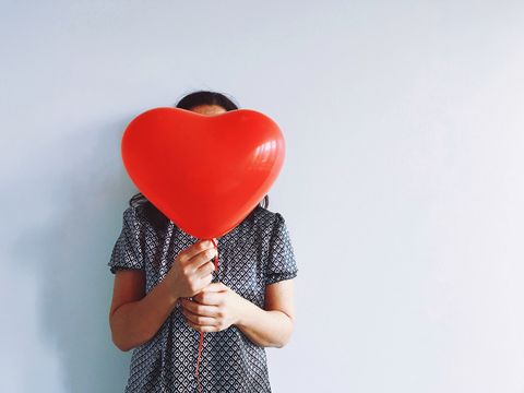 valentine's day party ideas, girl holding a heart shaped red balloon
