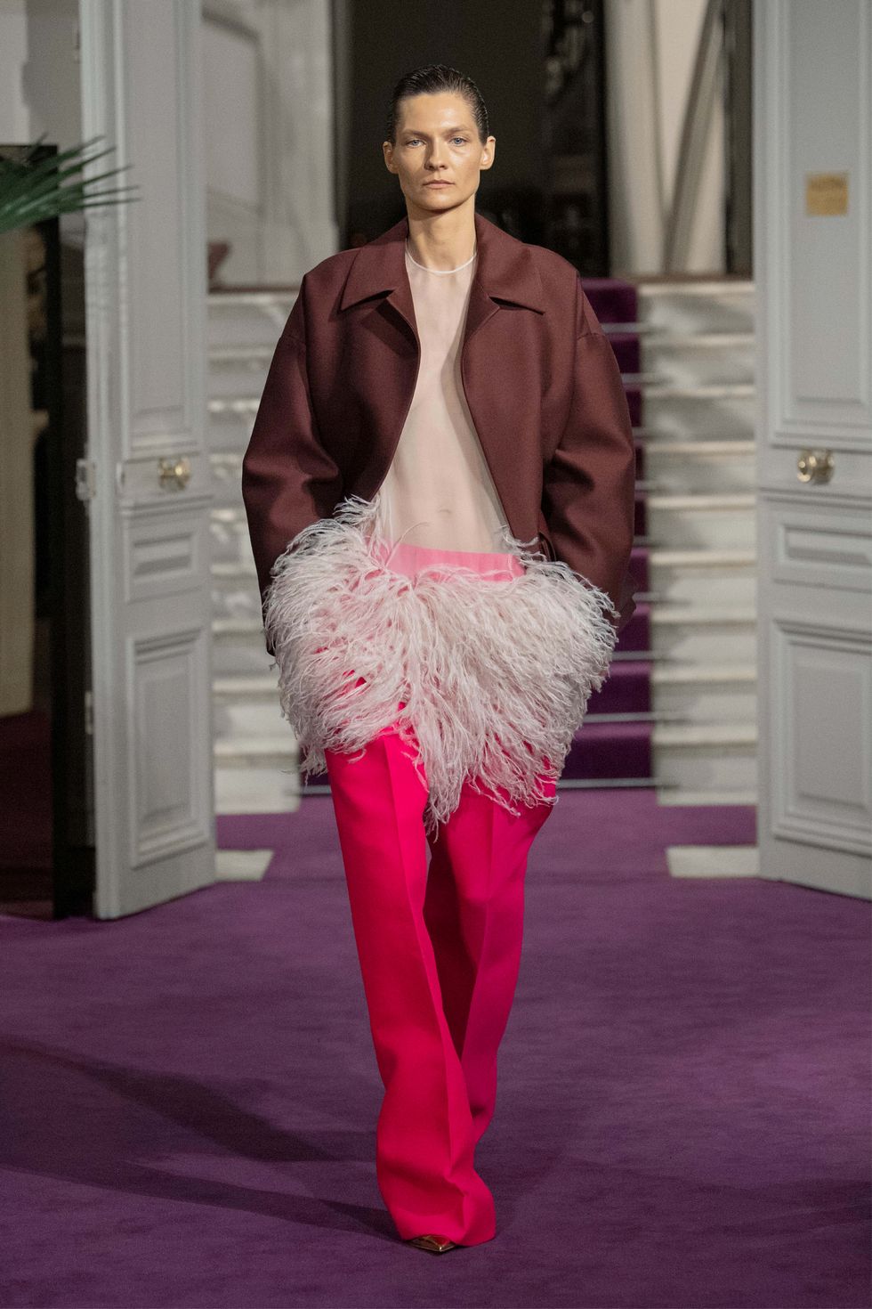 a woman wearing a pink coat and pink pants