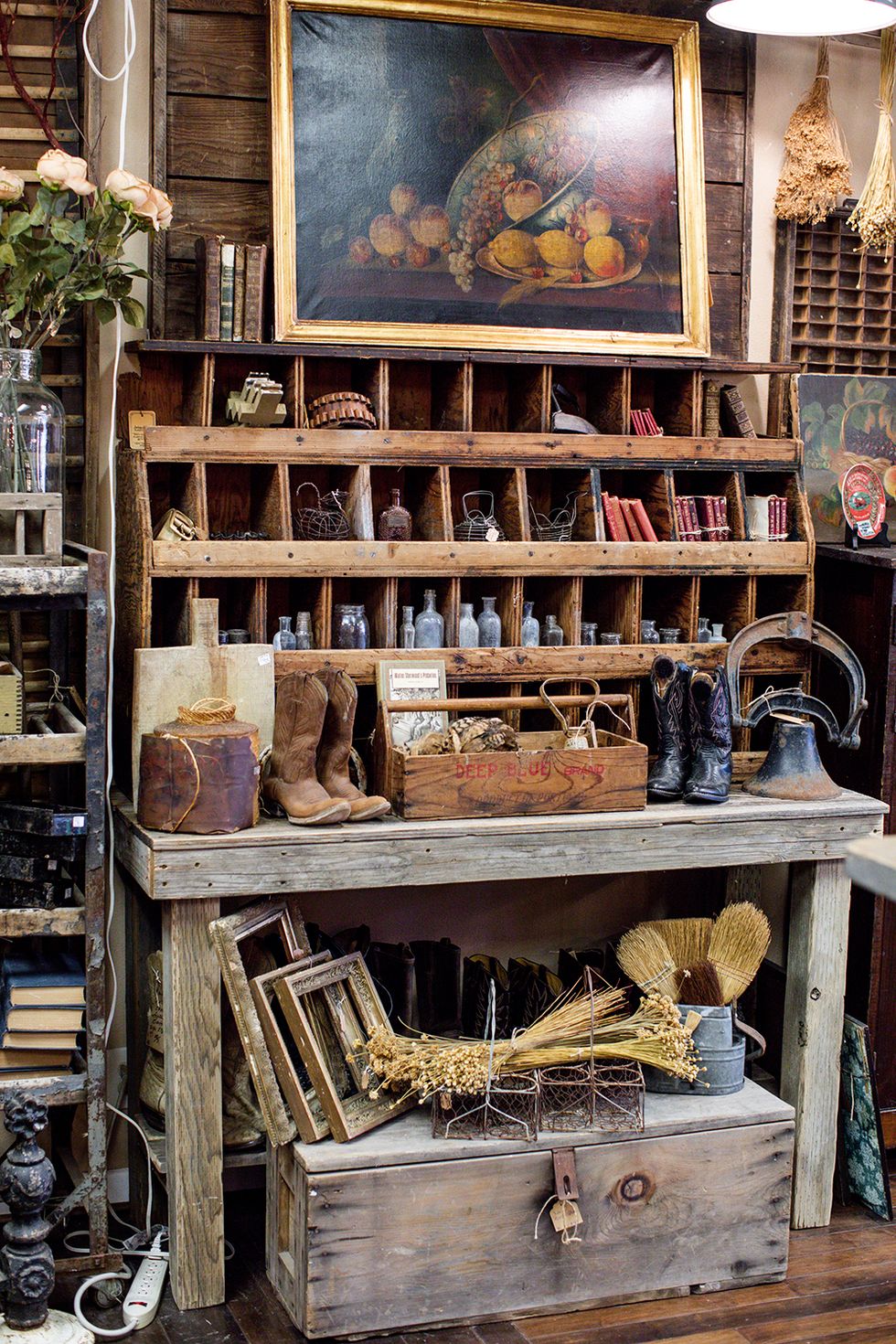 a rustic antique store vignette featuring cowboy boots and old bottles