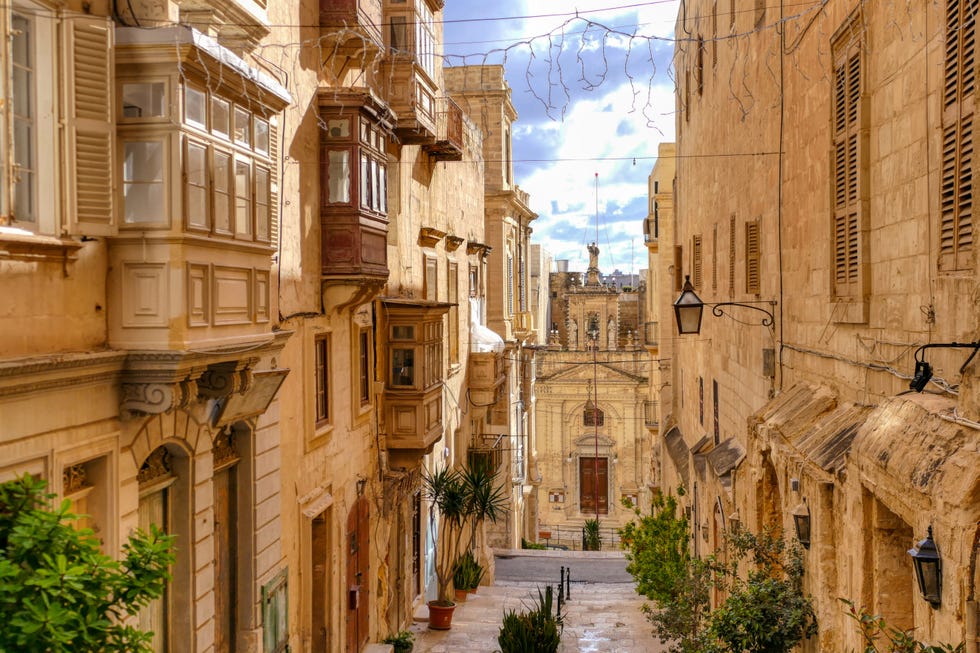 valletta malta rays of sunshine illuminating buildings in an empty alleyway in downtown valletta