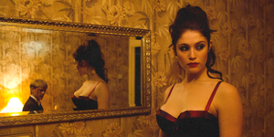 two vampires in a mirror and room with golden wallpaper