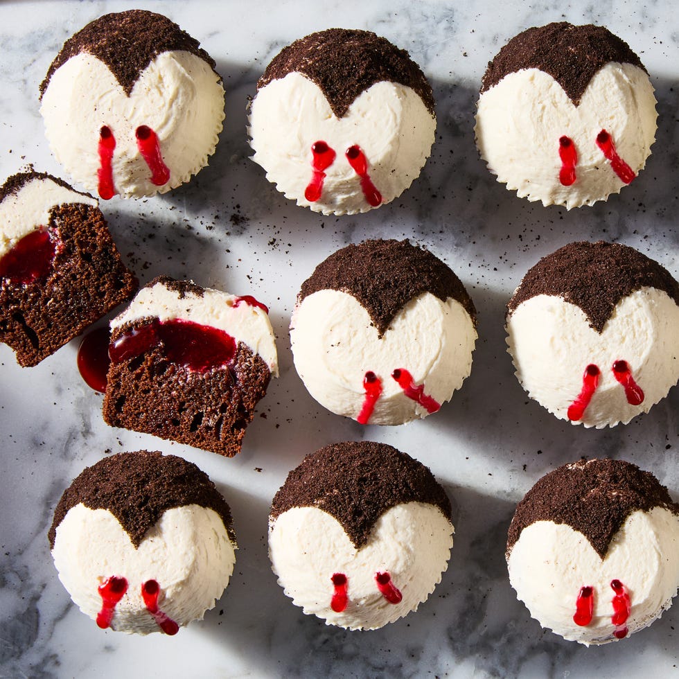 chocolate cupcakes topped with white icing and red lines