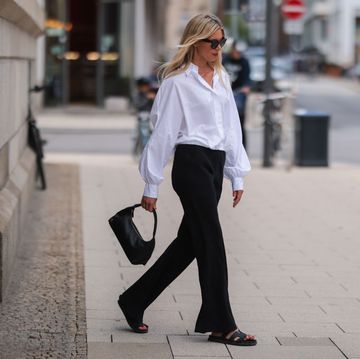 streetstyle foto in hamburg van vanessa gieser met witte blouse en zwarte broek met zwarte slippers en zwarte tas