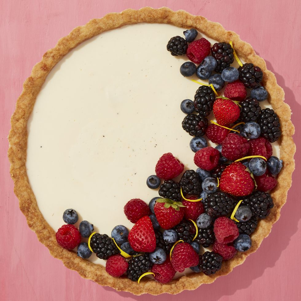 vanilla tart with berries arranged in crescent moon shape on top