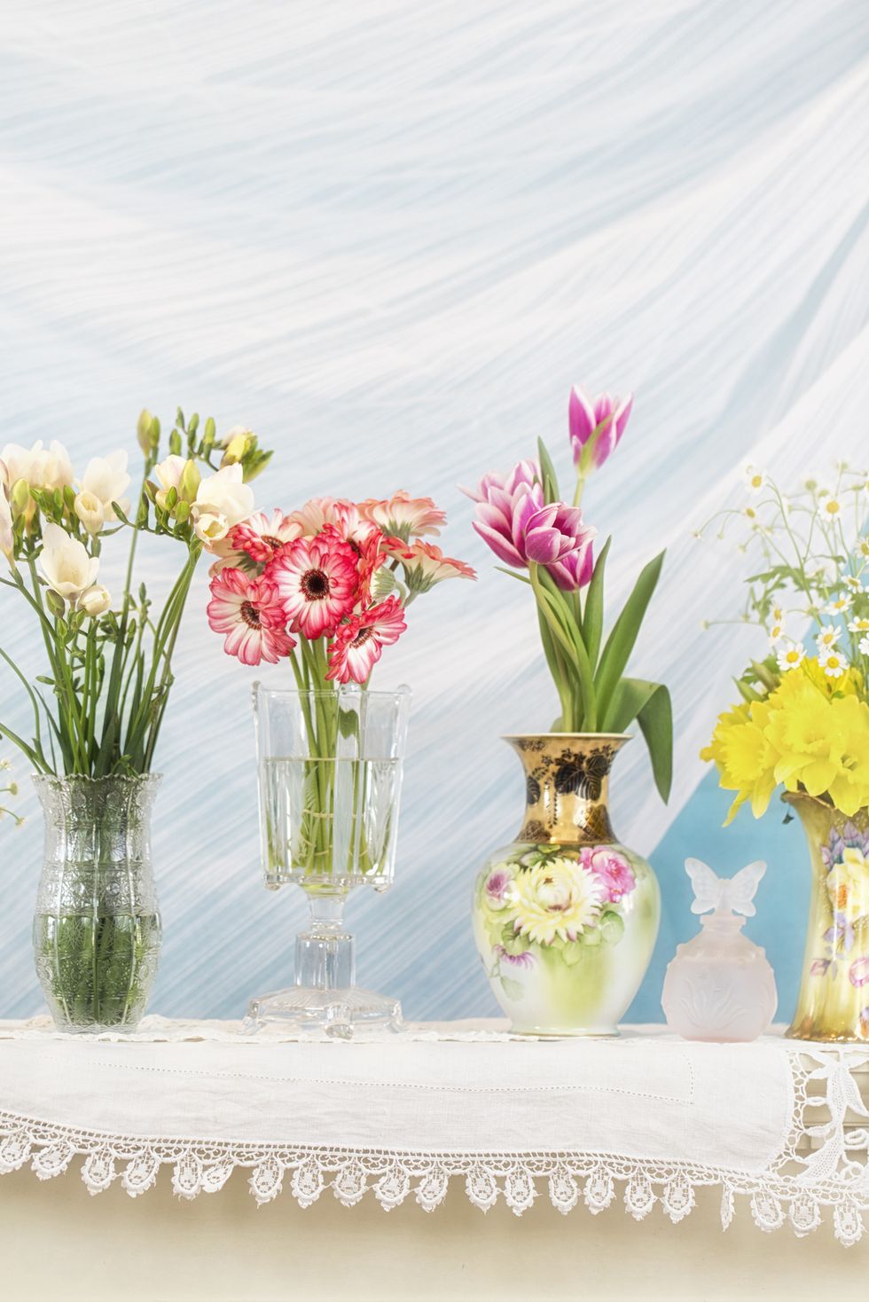variety of flowers in different vintage and antique vases