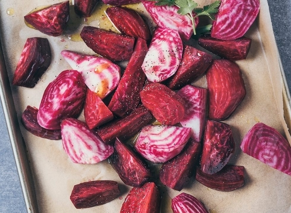 variety of sliced beets on a baking sheet on gray background