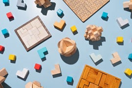 a variety of wooden puzzle toys flat lay on blue