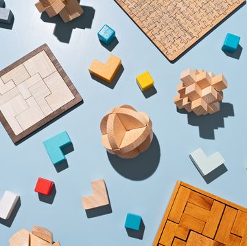 a variety of wooden puzzle toys flat lay on blue