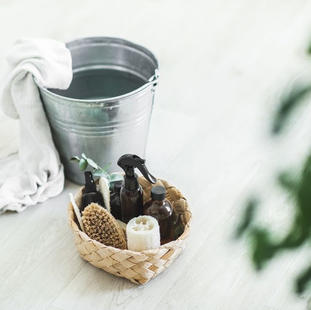 various eco cleaning items and supplies and metal bucket for cleaning on wooden floor.