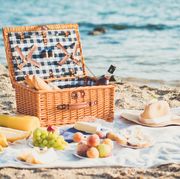 Various Fruits In Basket On Picnic Blanket At Shore