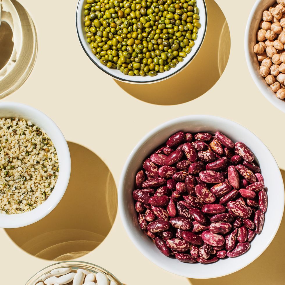 various kinds of vegan protein sources on beige background. set of food supplements. gluten free cereals as ground hemp seeds, quinoa. nuts and legumes (green mung beans, chick pea, red lentil, kidney bean, almonds, hazelnuts). flat lay, top view
