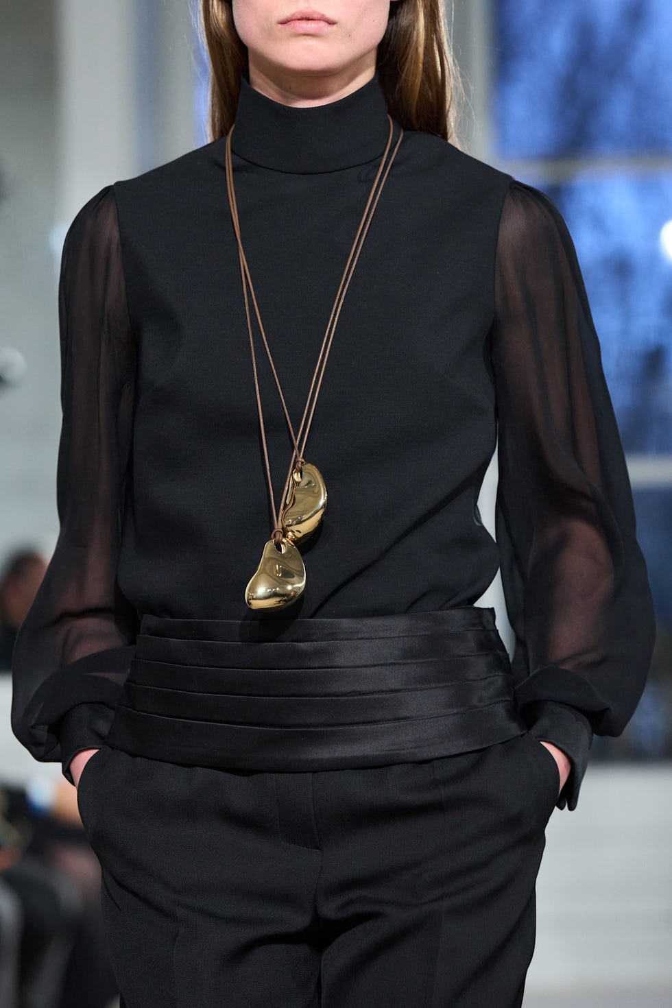 Fashion model showcasing a sophisticated outfit with a unique necklace