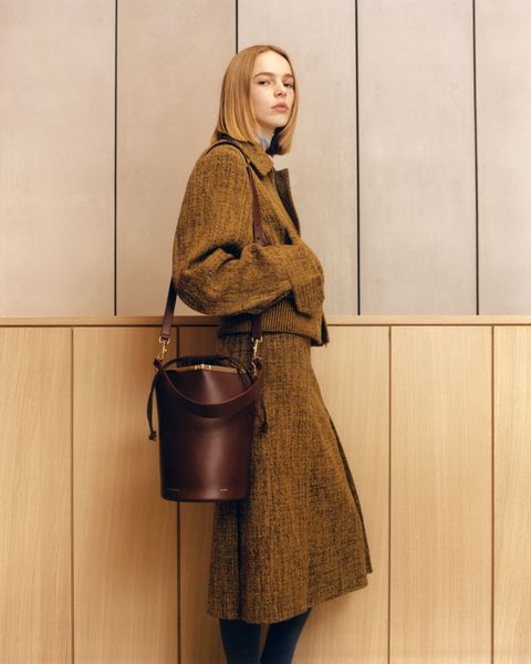a model carries a leather bucket bag from victoria beckham to illustrate a post about victoria beckham launching bags