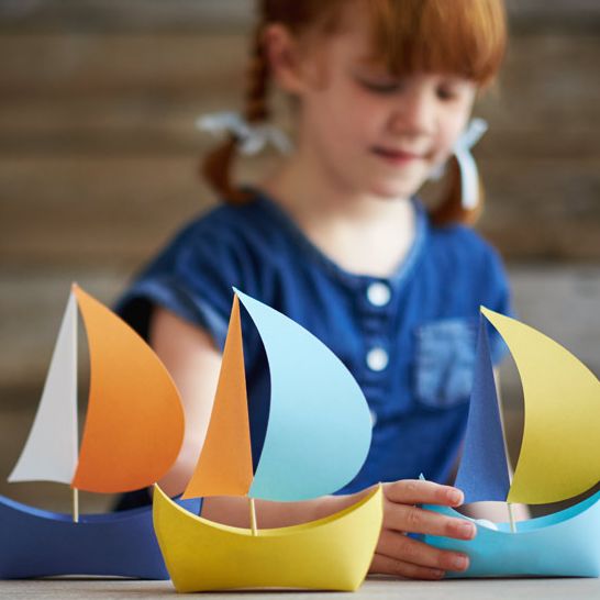 girl making a paper boat craft