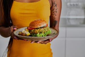 vrouw met boordje met vegan hamburger