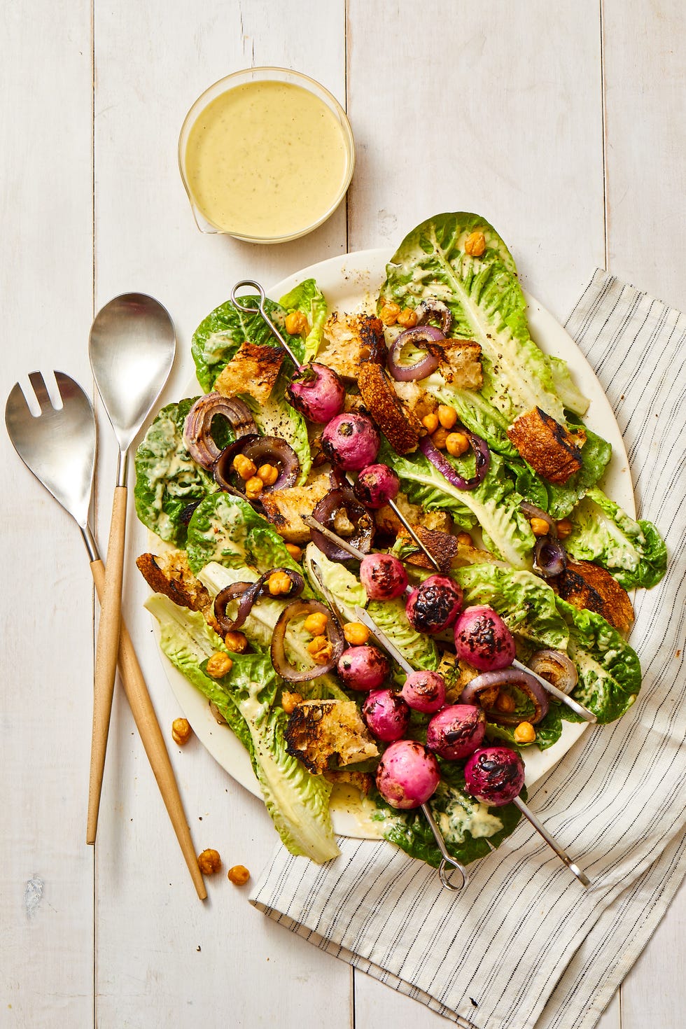 vegan caesar salad with skewers of charred radishes