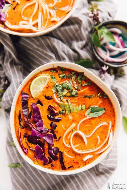 orange soup with noodles and cabbage and lime