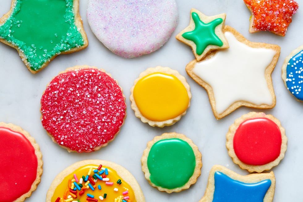 vegan sugar cookies topped with icing and sprinkles in various colors
