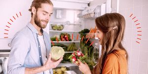 una coppia davanti al frigorifero con la verdura in mano