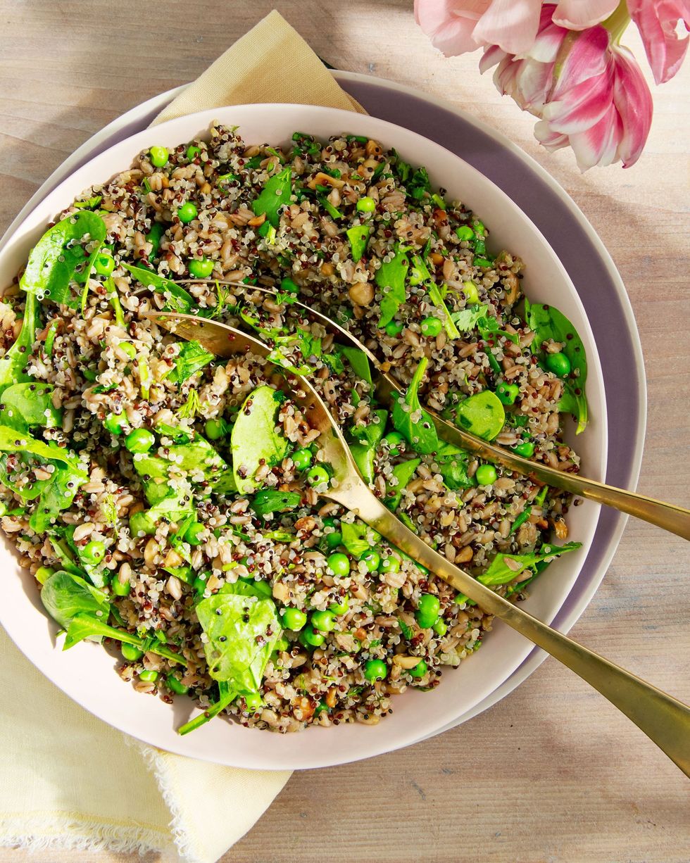 farro and quinoa salad with spinach and peas in a bowl with serving utensils