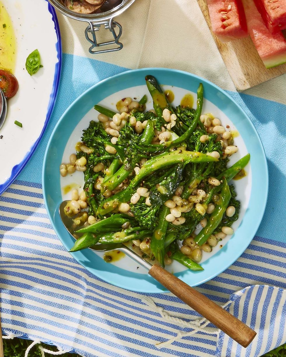 white bean and broccolini salad on a light blue plate with a serving spoon