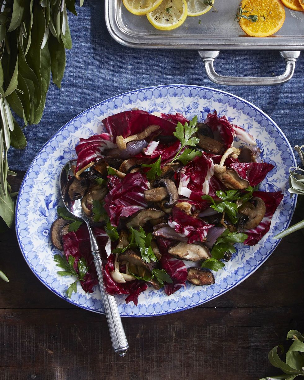 roasted mushrooms and radicchio on an antique blue oval serving plate with a spoon