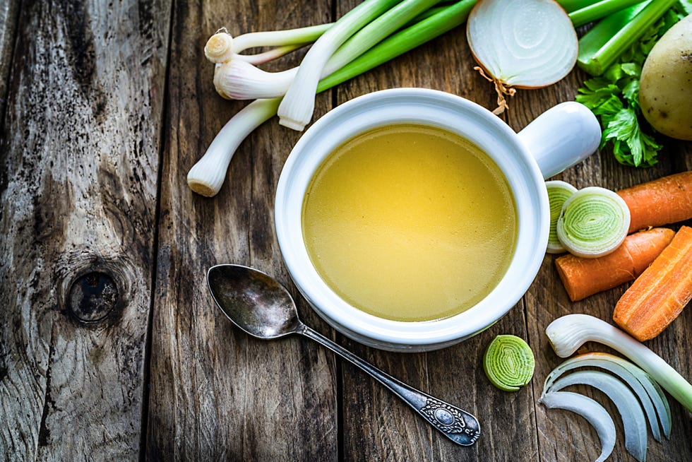 vegetables broth with ingredients shot on rustic kitchen table