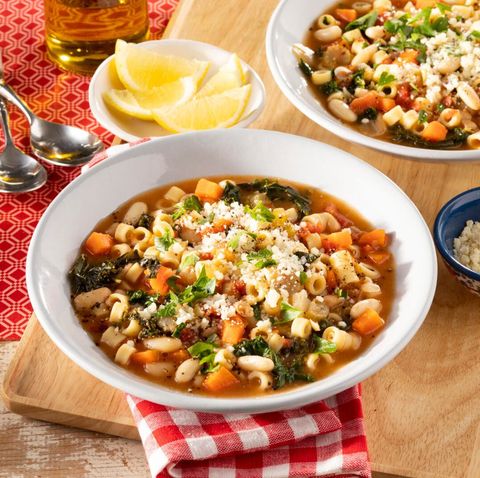 pasta fagioli in bowl with lemons on side and red napkin