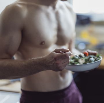 un hombre come comida vegetariana después de su entrenamiento