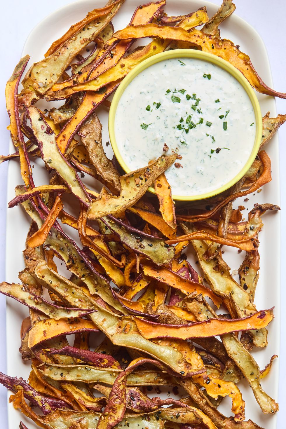 roasted veggie peels on a platter served with a creamy dip