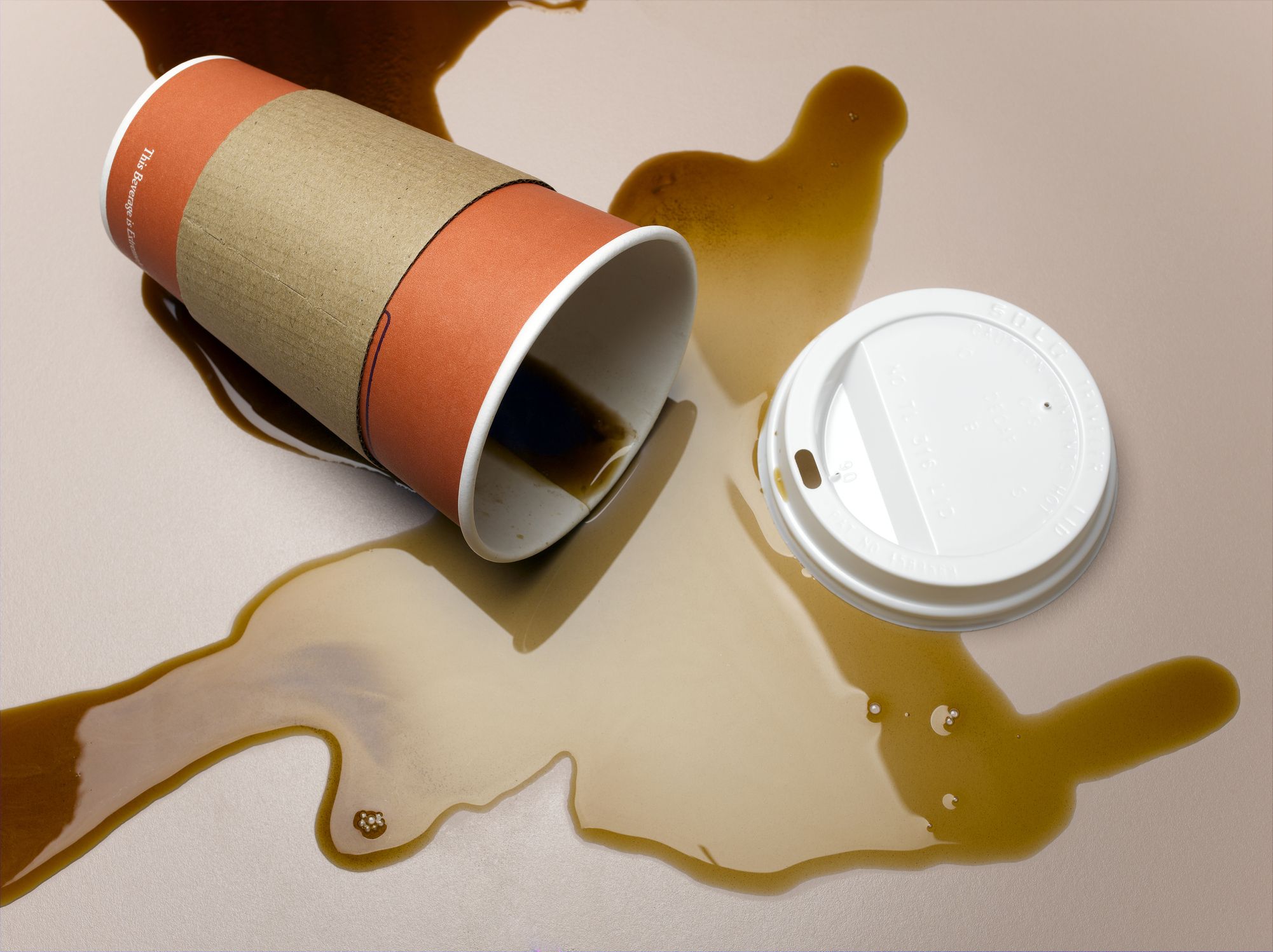https://hips.hearstapps.com/hmg-prod/images/vending-cup-on-side-spilling-coffee-onto-surface-royalty-free-image-1651507034.jpg
