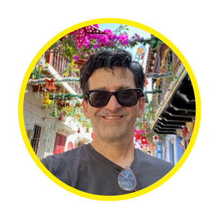 a selfie taken in a vibrant street decorated with colorful flowers and ornaments