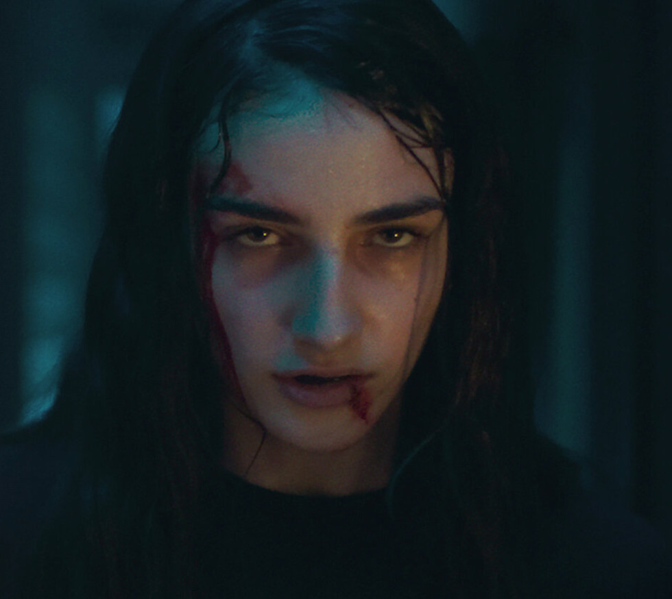 a girl glaring at the camera with a bloody mouth
