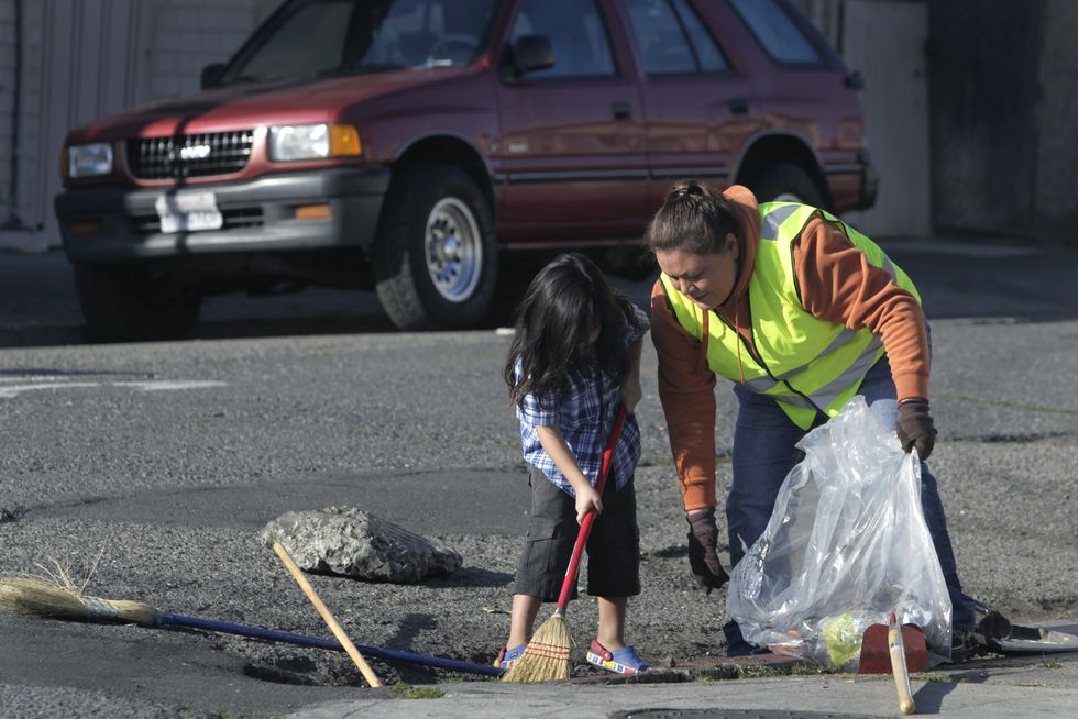 veronica tril right removes trash and debris from a storm drain with her son timmy, 4, near their 36th avenue home in oakland, calif on saturday, jan 4, 2014 the city of oakland is encouraging residents to adopt storm drains in their neighborhood to