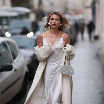 paris, france january 22 chloe lecareux seen wearing white silk laced long silk dress, beige long wool coat, white small shimmery handbag, silver big earrings and white high heels outside georges hobeika show during the haute couture springsummer 2024 as part of paris fashion week on january 22, 2024 in paris, france photo by jeremy moellergetty images