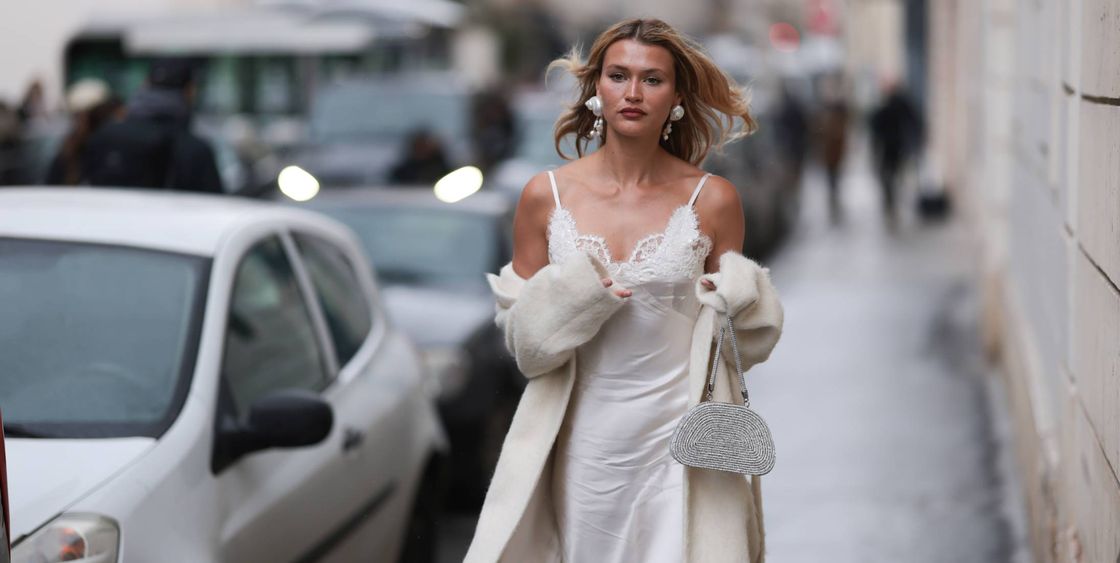paris, france january 22 chloe lecareux seen wearing white silk laced long silk dress, beige long wool coat, white small shimmery handbag, silver big earrings and white high heels outside georges hobeika show during the haute couture springsummer 2024 as part of paris fashion week on january 22, 2024 in paris, france photo by jeremy moellergetty images