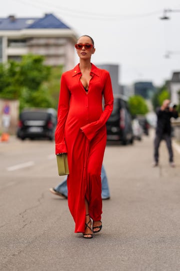 milan, italy september 18 a guest wears dark red sunglasses, silver earrings, bright red long sleeve buttoned maxi dress, light green leather bag, black open toe heels, outside jil sander, during the milan fashion week springsummer 2024 2025 on september 18, 2024 in milan, italy photo by edward berthelotgetty images