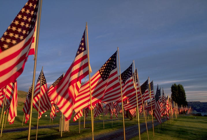 american flags wave in the late afternoon light of memorial day at spring canyon cemetery in eastern washington state location washington, usa