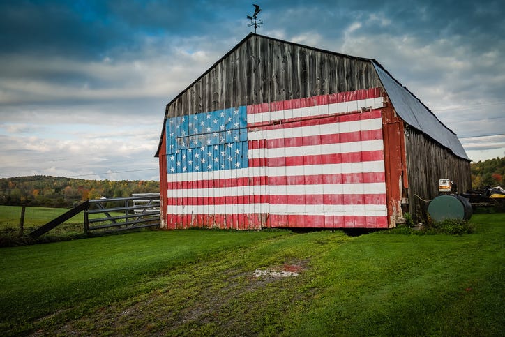 a large barn with a cross on top and an american flag