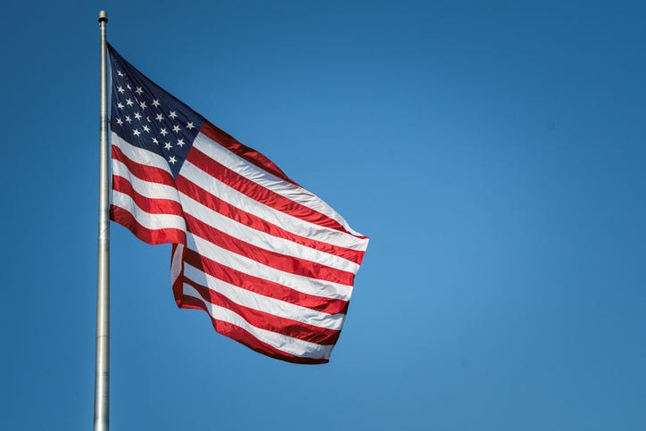 the american flag waving against a blue sky