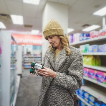 een vrouw leest een etiket van vitamines