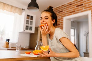 een vrouw eet een sinaasappel