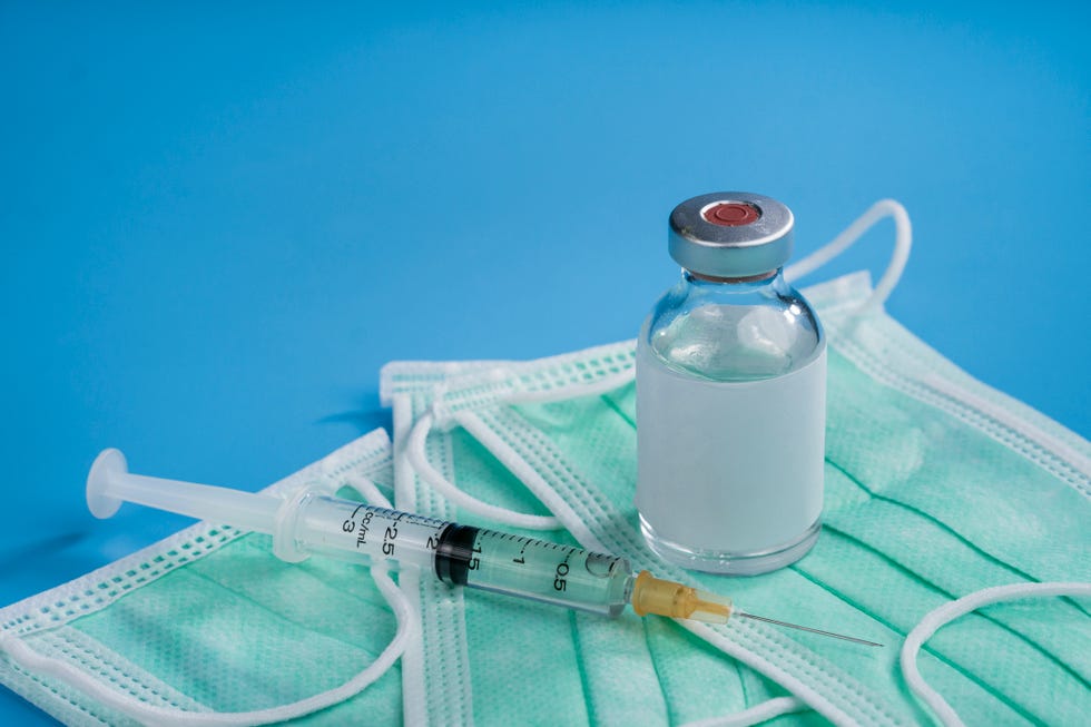 vial of coronavirus vaccine with syringe and mask