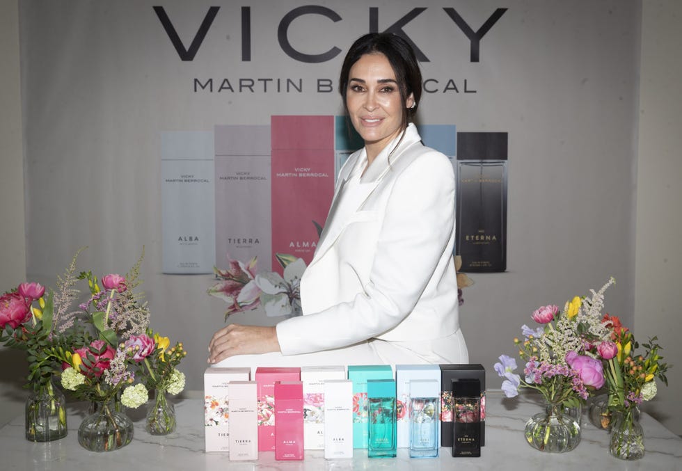 la diseñadora con un traje blanco posa con sus nuevas fragancias