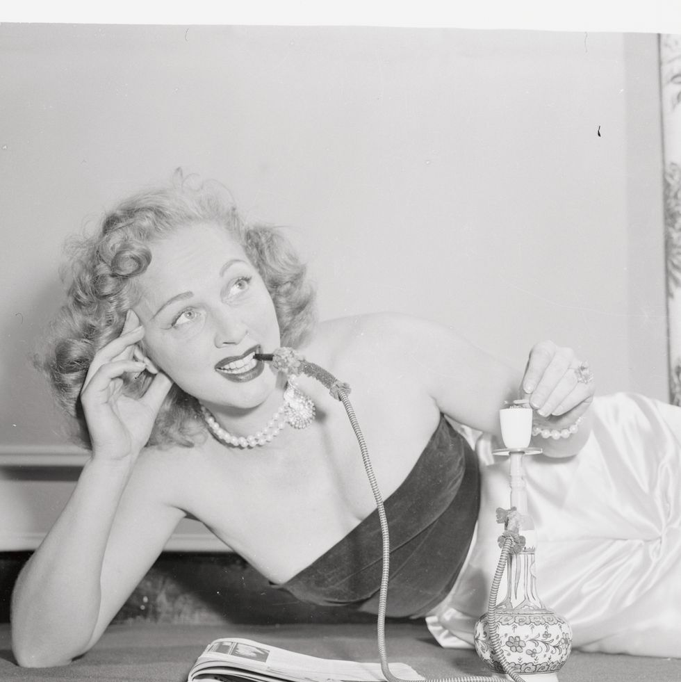 video actress elaine shepard lounges oriental fashion smoking a turkish pipe called a "hookah" in turkey, where elaine has lived for years with her husband, woman have smoked pipes for centuries hookah smoking may be on answer to chain smoking since a pipeful lasts an hour it's real "cool" for the smoke if filtered through water
