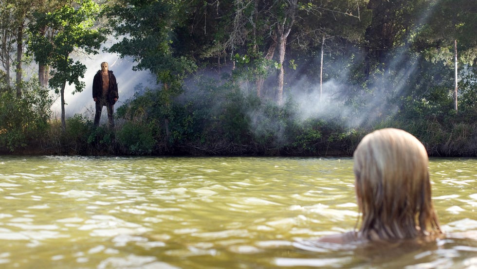 chica en el lago mientras el asesino de viernes 13 la mira desde la orilla
