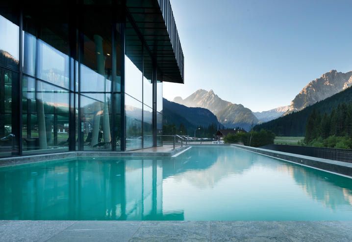 Swimming pool, Property, Reflection, Glass, Mountain range, Real estate, Aqua, Azure, Resort, Composite material, 