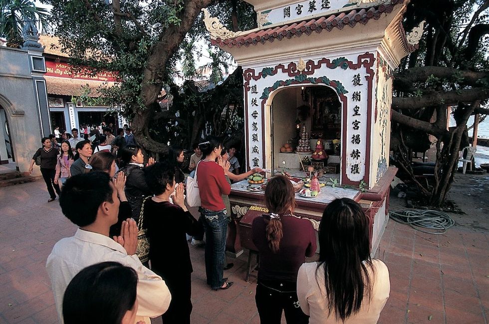 Biddende mensen bij de Tran Quoc tempel in Hanoi